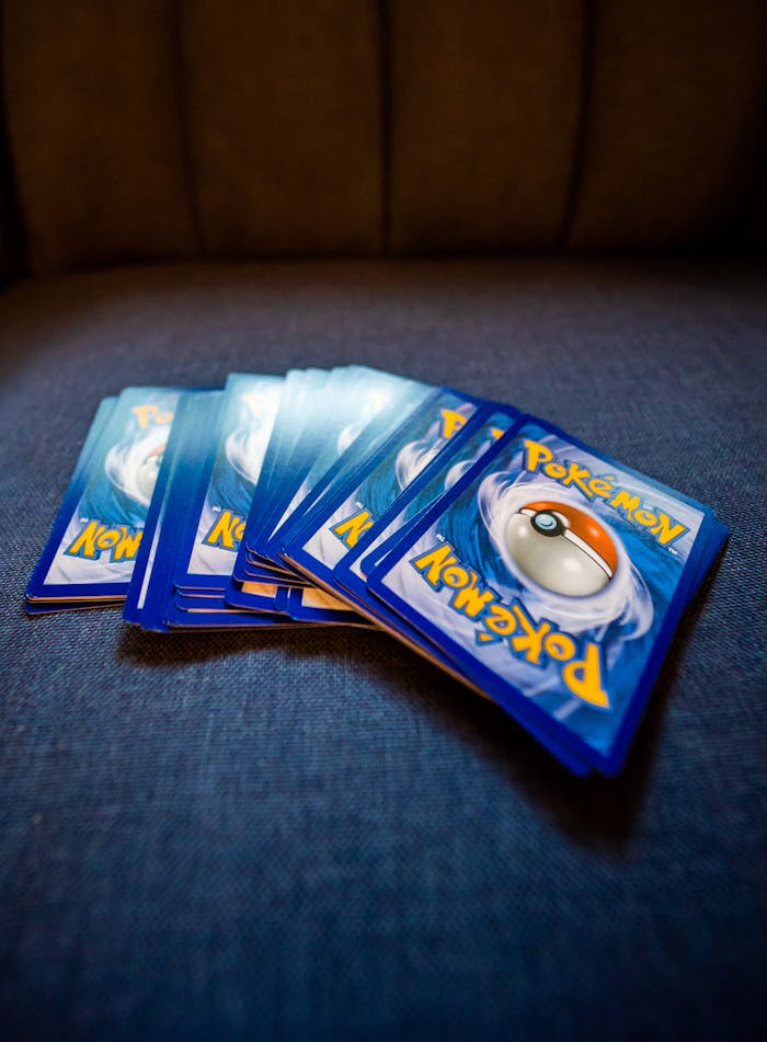 A collection of Pokemon trading cards arranged on a blue couch, ideal for collectors and fans.
